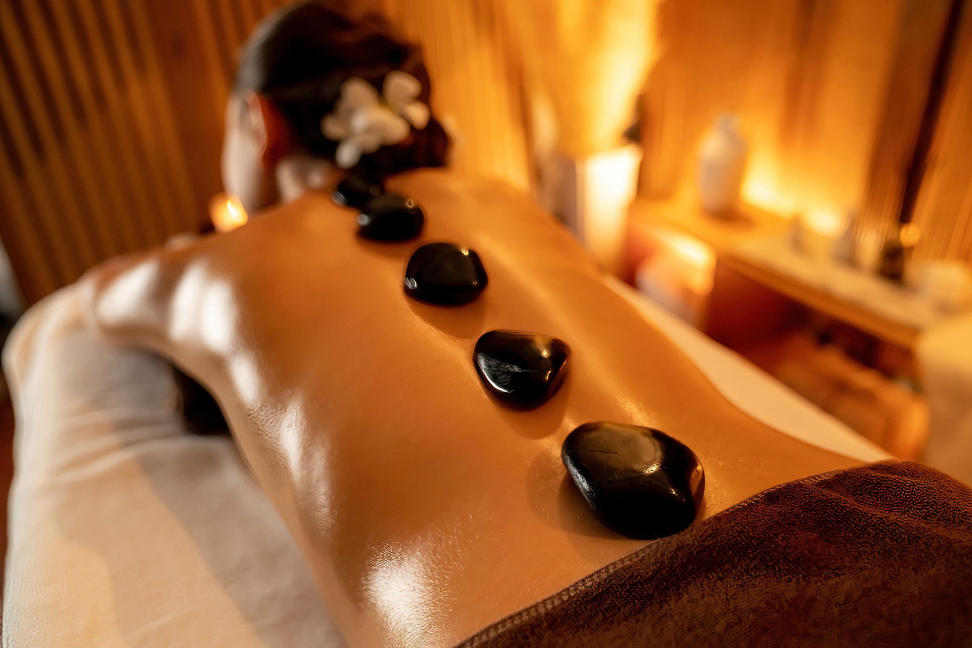 Hot stone massage at spa salon in luxury resort with warm candle light.Quiescent