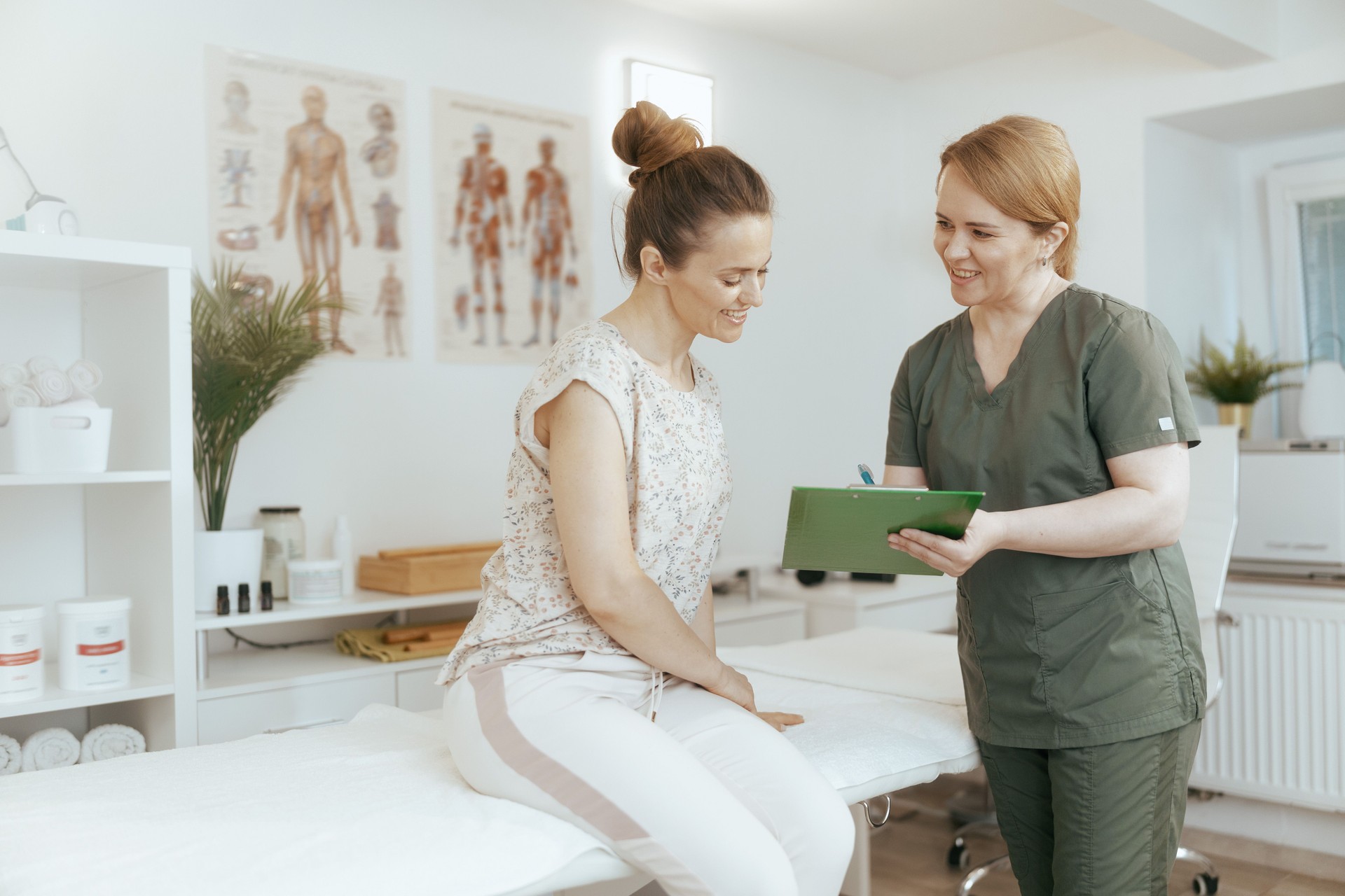 female therapist conducting examination and writing in clipboard