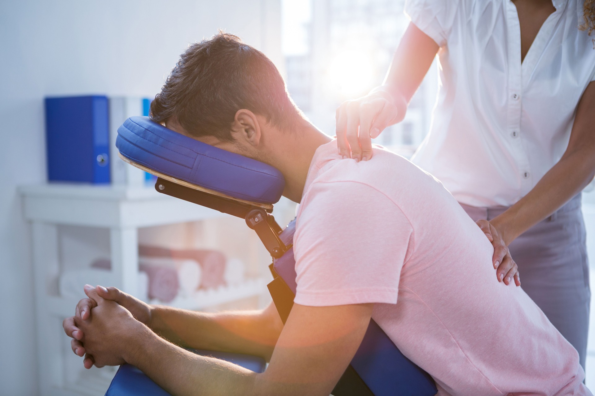 Physiotherapist giving back massage to a patient